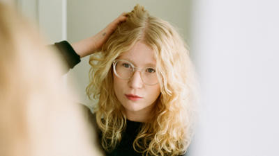 woman fluffing hair and looking in mirror